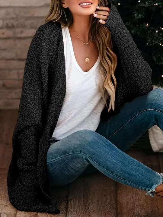A cardigan laid flat to dry: the weight is supported along the whole garment, which is the difference between a sweater that keeps its length and one that grows.